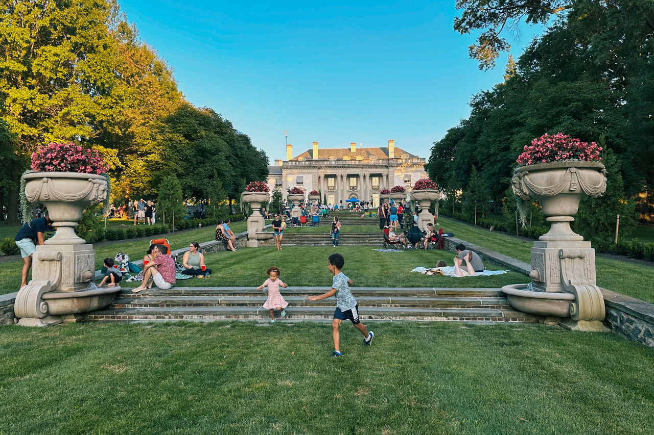 Children playing together while families enjoy the beautiful weather on the Nemours Estate property.